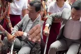 Mạnh Quỳnh về Việt Nam, phải ngồi xe lăn và chống nạng