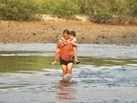 Không có cầu, cha mẹ "nín thở" cõng con vượt sông đến trường